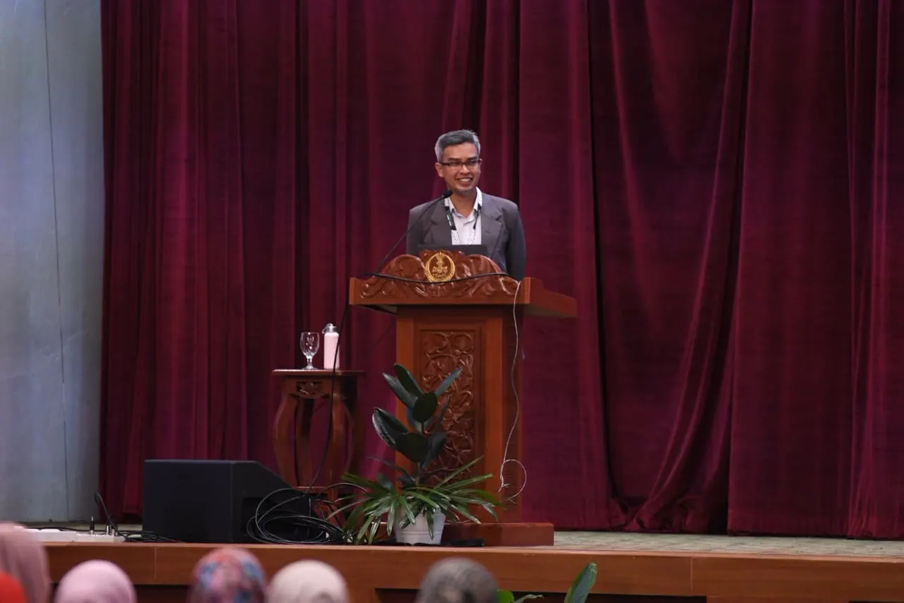 Dr. Khalis Amali Bin Mohamed Zuki speaking from an auditorium podium