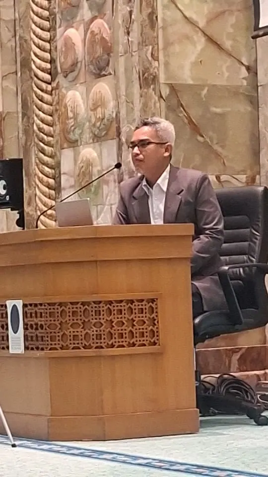 Facilitator speaking from the lectern at Masjid UTP
